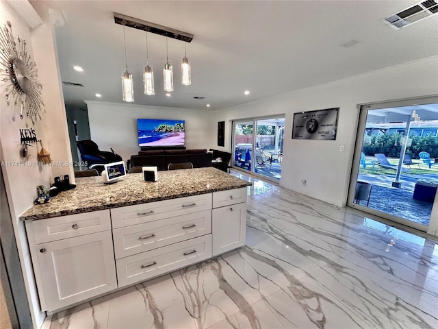 kitchen featuring white cabinetry, crown molding, hanging light fixtures, and light stone counters