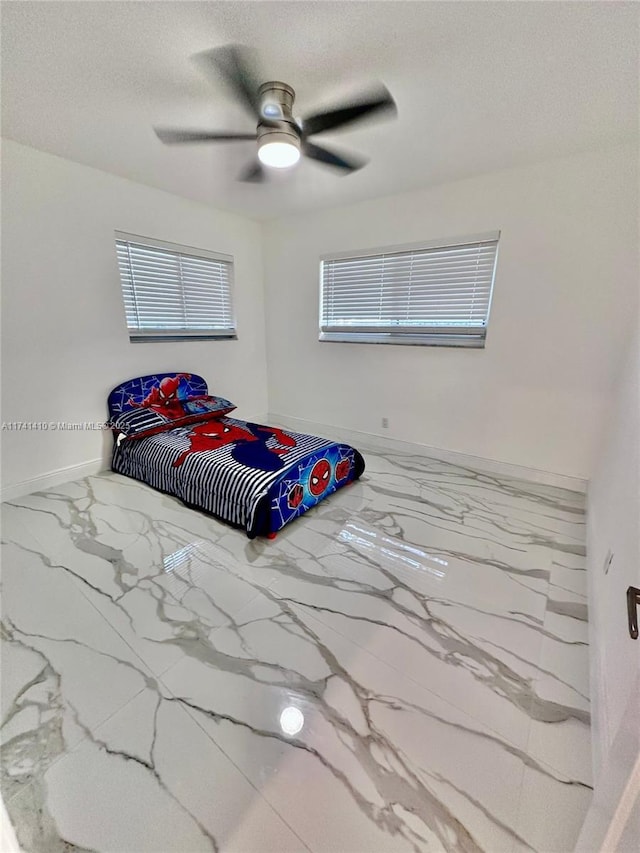 bedroom featuring ceiling fan and a textured ceiling