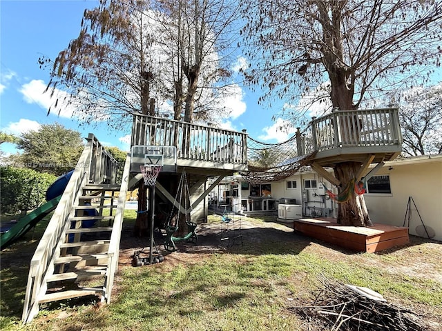 back of property with a wooden deck and a yard