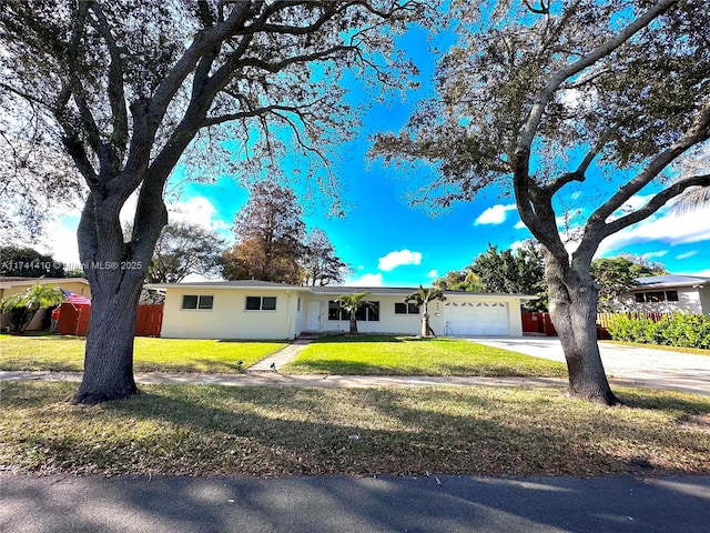 single story home with a garage and a front lawn