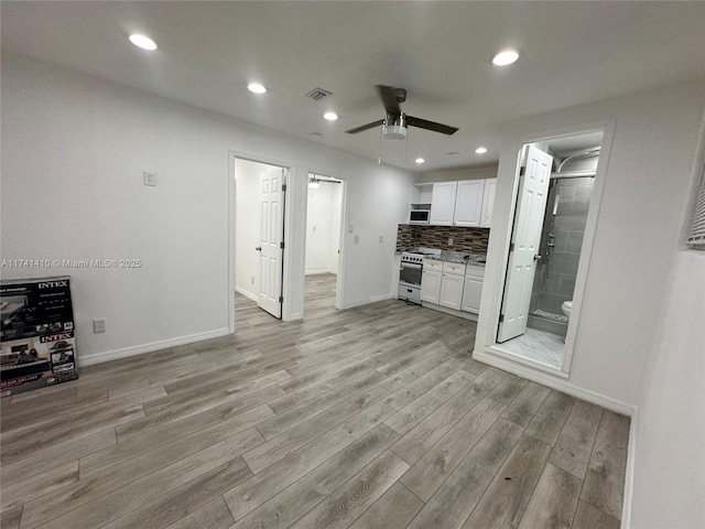 kitchen with white electric range, ceiling fan, white cabinets, decorative backsplash, and light wood-type flooring