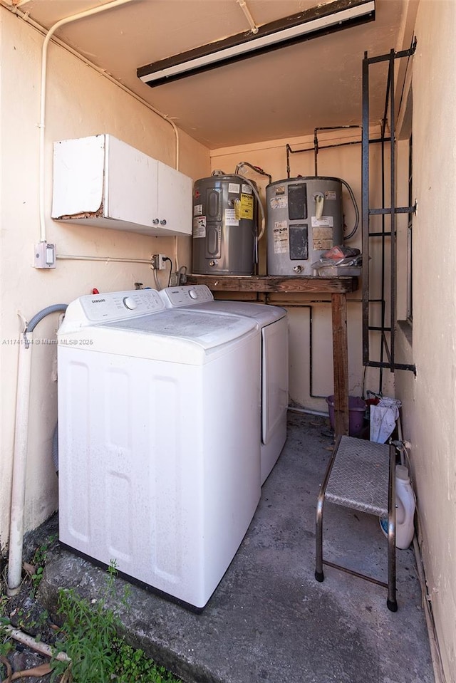 clothes washing area featuring electric water heater and washer and dryer