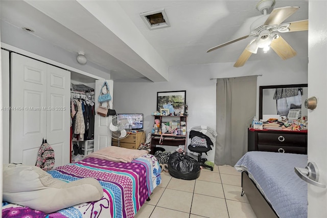 bedroom with light tile patterned floors, ceiling fan, and a closet