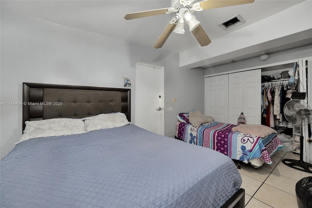 bedroom with light tile patterned floors, a closet, and ceiling fan