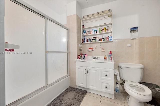 full bathroom with toilet, shower / bath combination with glass door, tile walls, vanity, and tile patterned flooring