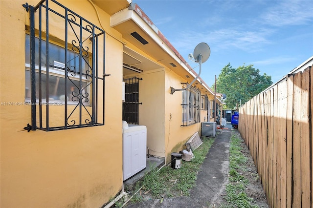 view of home's exterior featuring washer / dryer and cooling unit