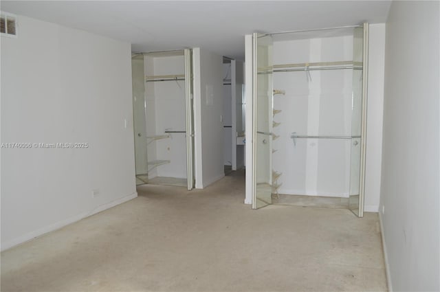 unfurnished bedroom featuring visible vents, two closets, carpet floors, and baseboards