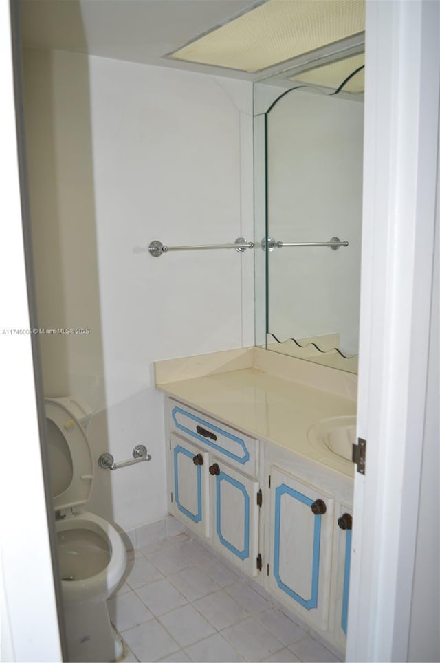 bathroom featuring vanity, tile patterned floors, and toilet