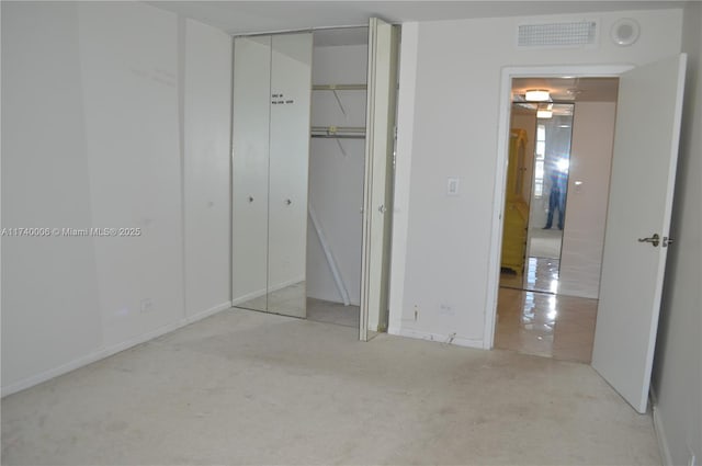 unfurnished bedroom featuring baseboards, visible vents, a closet, and carpet