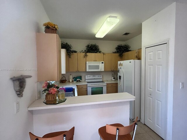 kitchen featuring light tile patterned flooring, light brown cabinetry, a breakfast bar area, kitchen peninsula, and white appliances