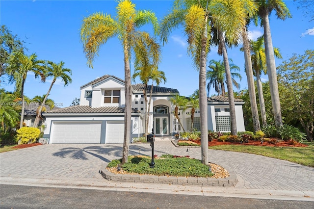 mediterranean / spanish home with a garage and french doors