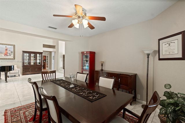 dining area featuring light tile patterned floors, a textured ceiling, and ceiling fan