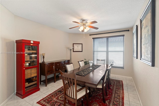 tiled dining room with ceiling fan and a textured ceiling