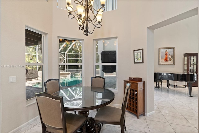 dining area with an inviting chandelier, a towering ceiling, and light tile patterned floors