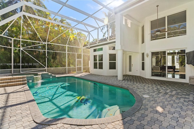 view of swimming pool with a patio area, an in ground hot tub, and glass enclosure