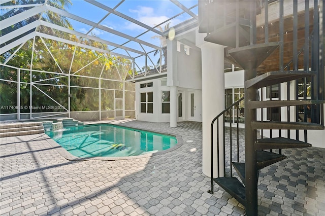 view of swimming pool featuring an in ground hot tub, glass enclosure, and a patio area