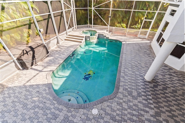 view of pool with a lanai, a patio, and an in ground hot tub