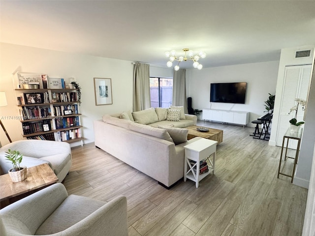 living room featuring a notable chandelier and light hardwood / wood-style flooring