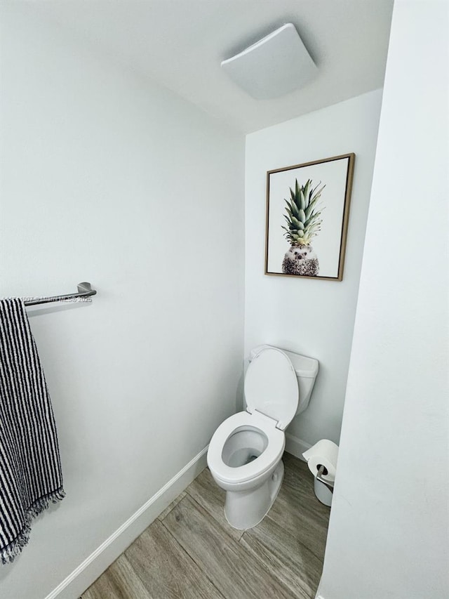 bathroom with toilet and hardwood / wood-style floors