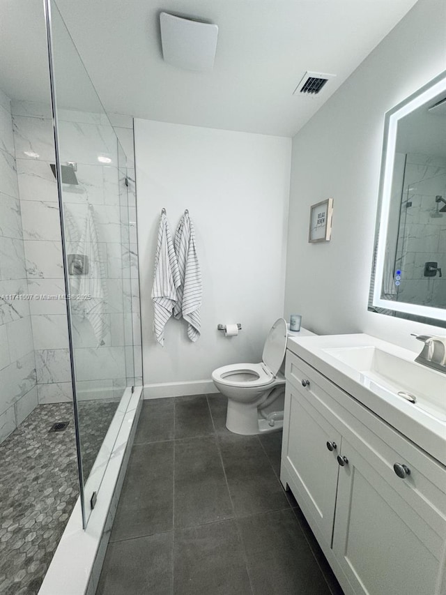 bathroom with vanity, a tile shower, tile patterned floors, and toilet