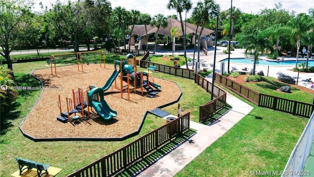 view of playground featuring a yard and a community pool