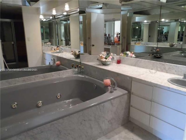 bathroom with sink and tiled tub