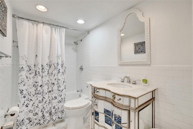 full bathroom with tile walls, vanity, toilet, and shower / tub combo with curtain