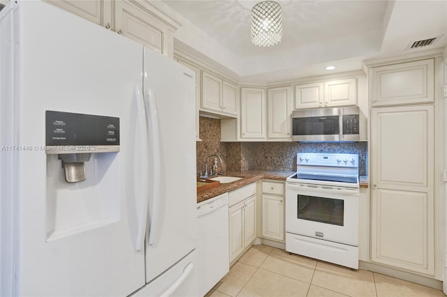 kitchen with sink, light tile patterned floors, backsplash, and white appliances