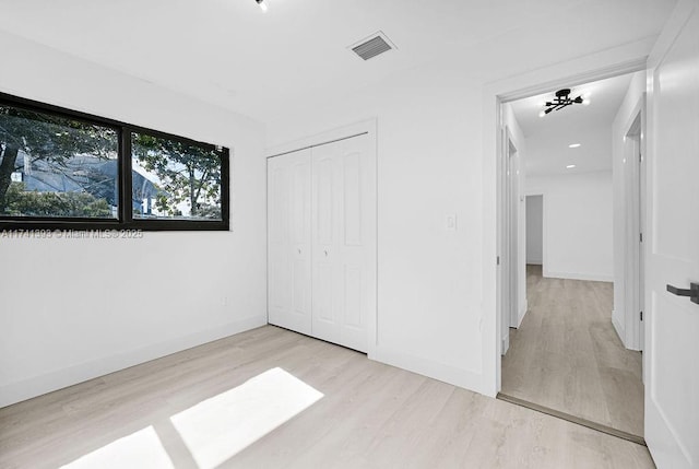 unfurnished bedroom featuring a closet and light wood-type flooring