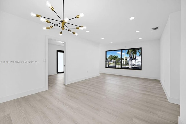 unfurnished living room with a chandelier and light hardwood / wood-style floors