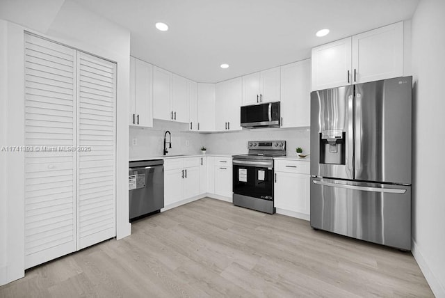 kitchen with stainless steel appliances, light hardwood / wood-style floors, sink, and white cabinets