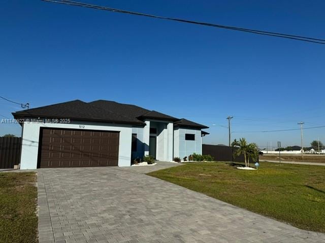 view of front of property with a garage and a front lawn