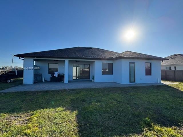 back of property with a patio area and a lawn