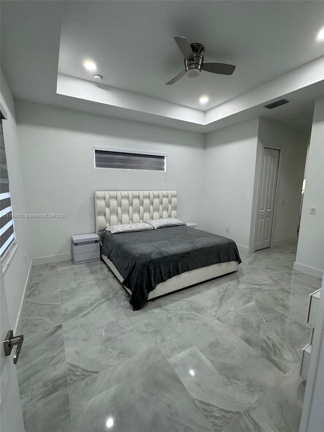 bedroom featuring a tray ceiling and ceiling fan