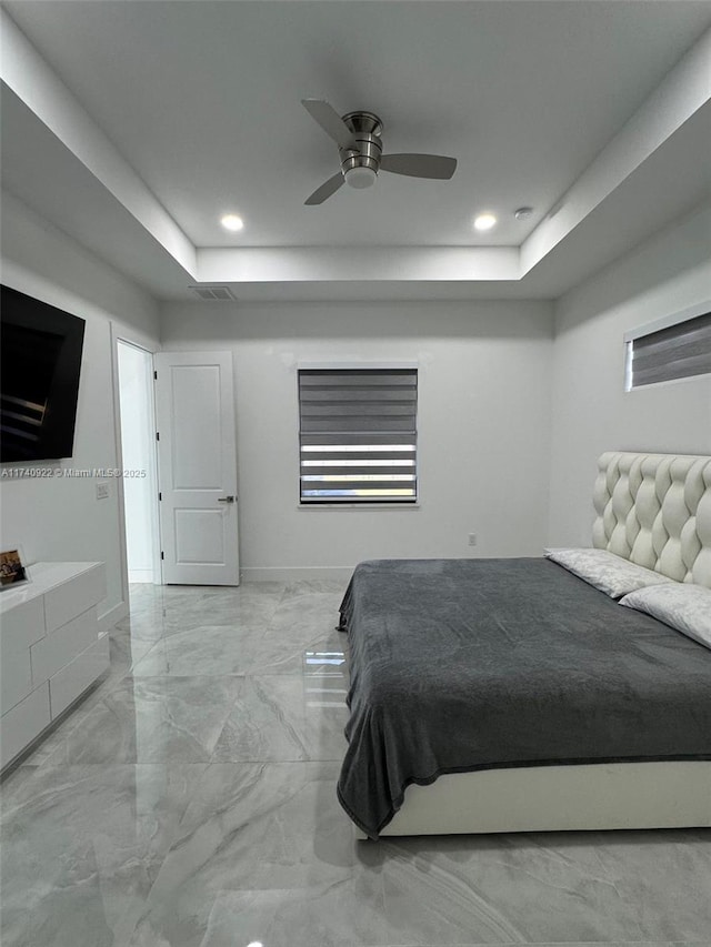 bedroom with a raised ceiling and ceiling fan