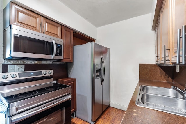 kitchen featuring stainless steel appliances, sink, and light wood-type flooring