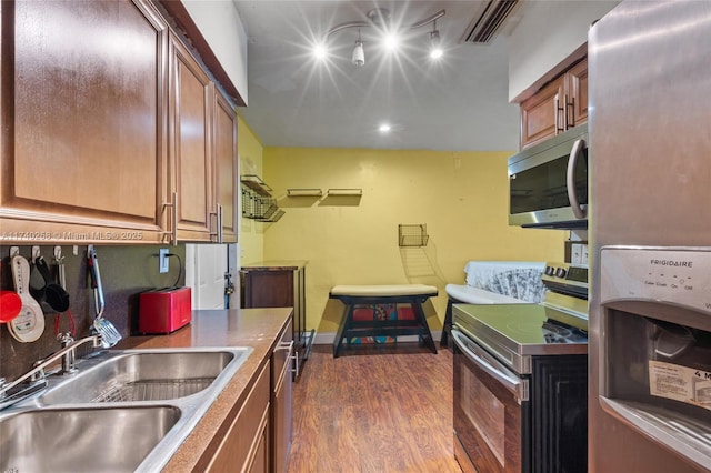 kitchen with stainless steel appliances, sink, and dark wood-type flooring