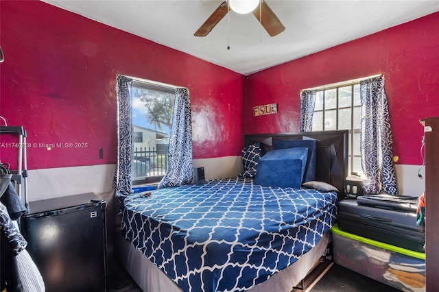 bedroom with stainless steel fridge and ceiling fan