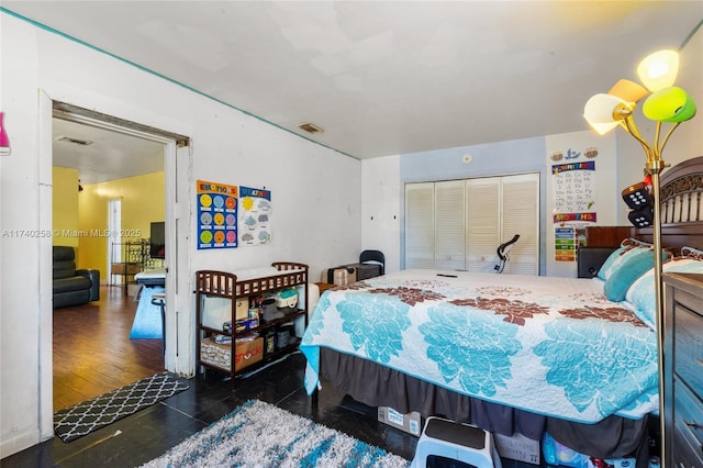 bedroom with dark hardwood / wood-style flooring and a closet