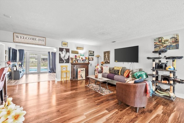 living room featuring french doors, hardwood / wood-style floors, and a textured ceiling