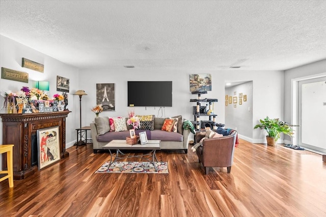 living room with hardwood / wood-style floors, a fireplace, and a textured ceiling