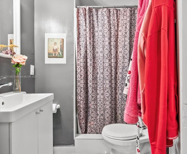 bathroom with vanity, curtained shower, and toilet