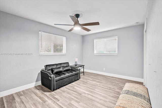 living area featuring ceiling fan, plenty of natural light, and light hardwood / wood-style floors