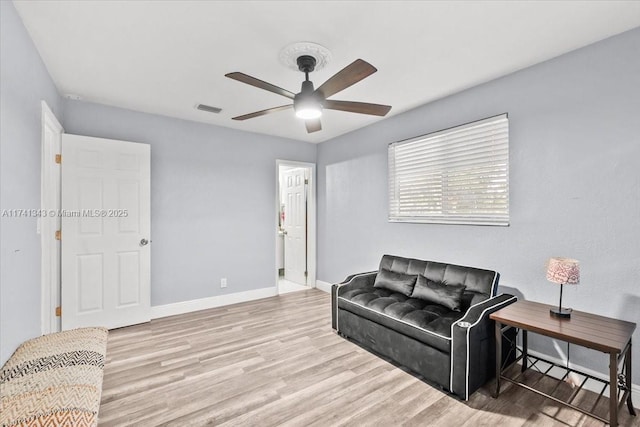 living room with ceiling fan and light hardwood / wood-style flooring