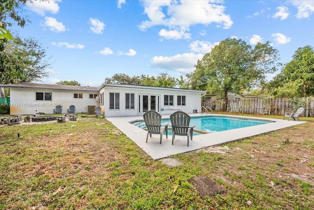 rear view of house featuring a fenced in pool, a yard, and a patio