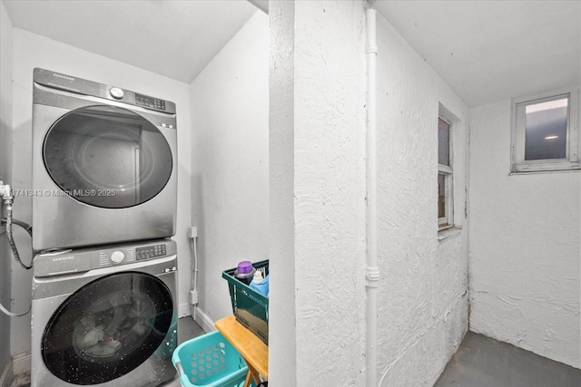 clothes washing area featuring stacked washing maching and dryer