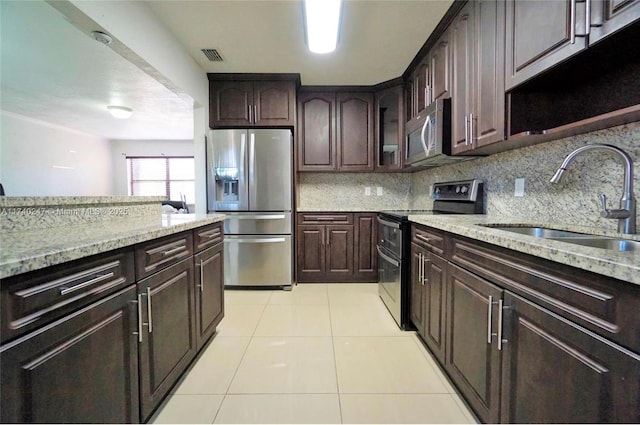 kitchen with stainless steel appliances, sink, and dark brown cabinets