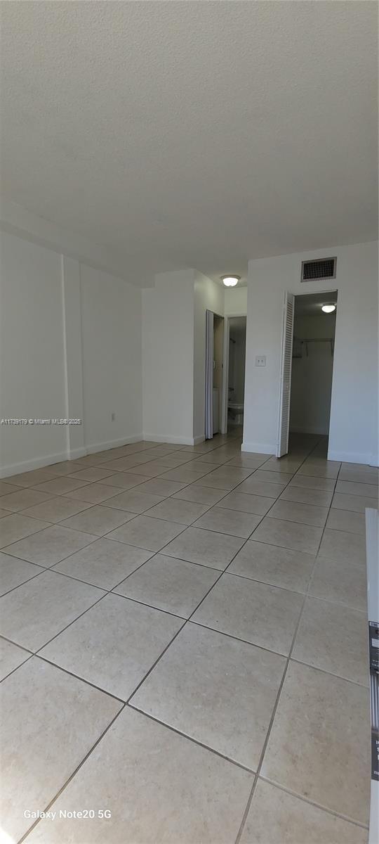 10900 SW 104th St Unit 316, Miami, FL 33176 - empty room with baseboards, light tile patterned flooring, a textured ceiling, and visible vents