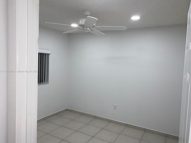 tiled empty room featuring ceiling fan