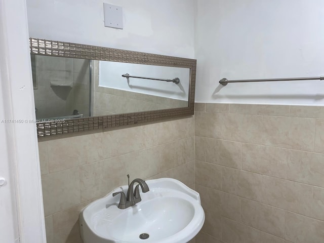 bathroom featuring tile walls and sink